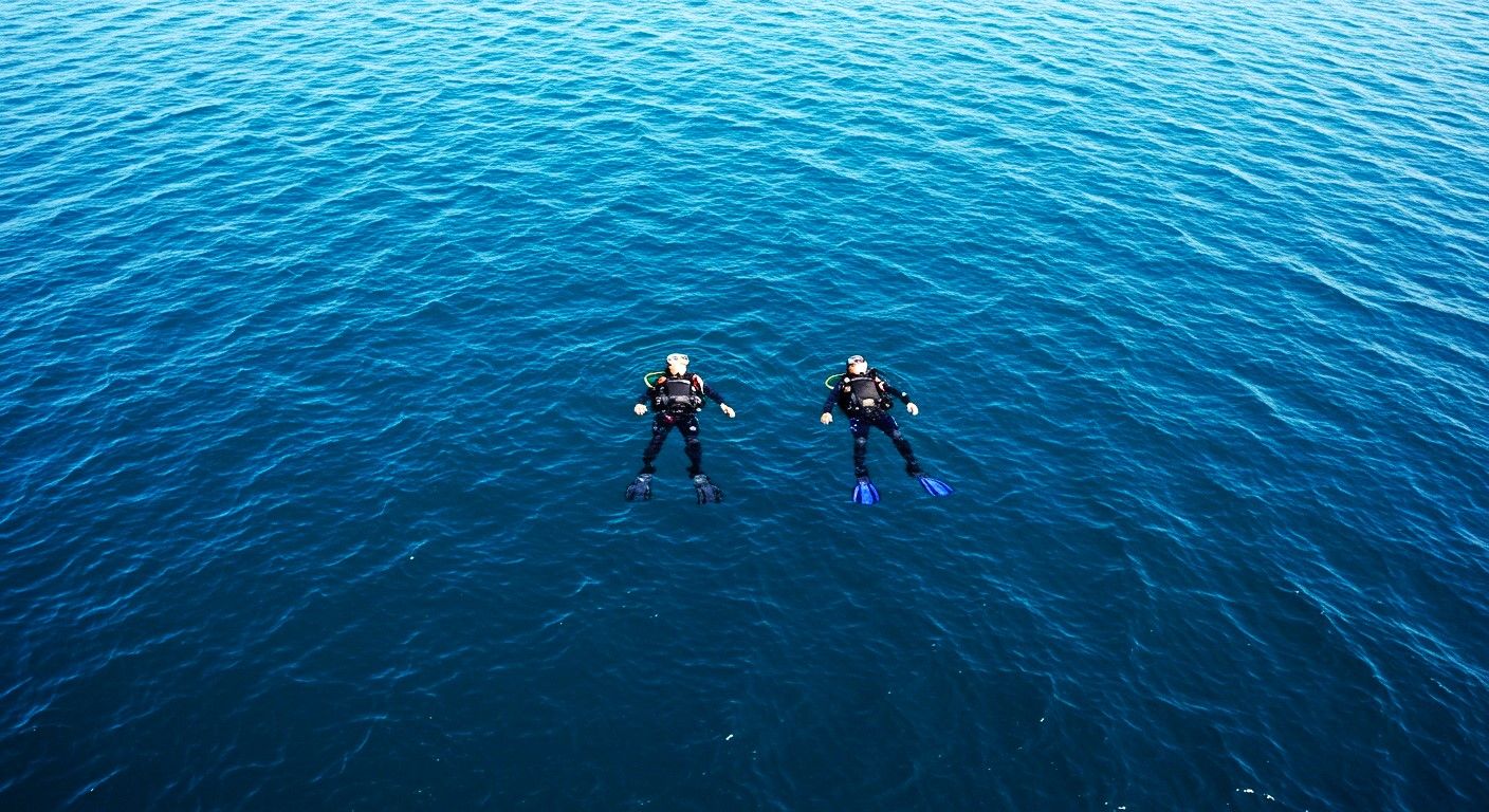 The artistic effect of two scuba divers floating on the surface of the ocean in open water