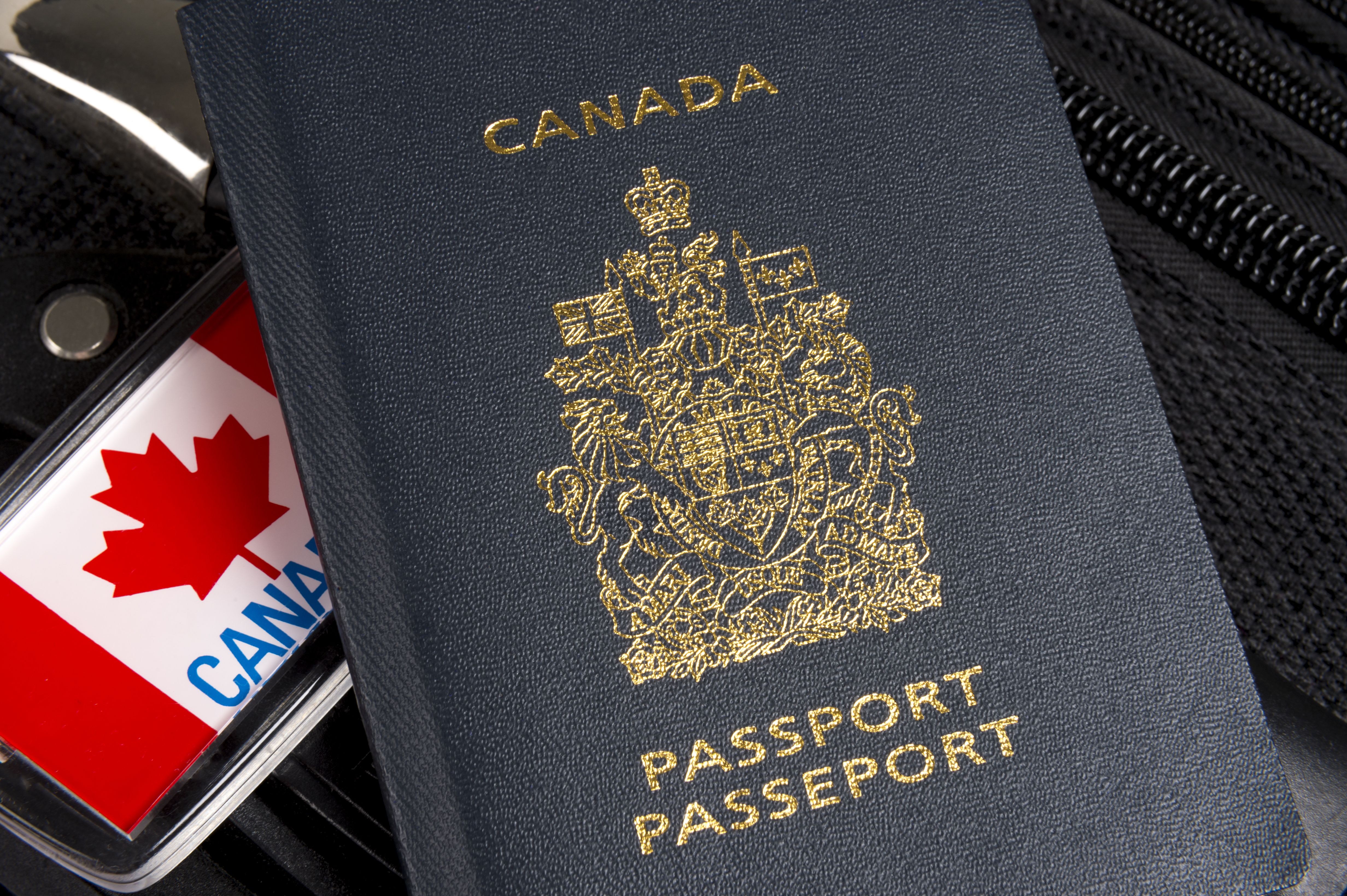 Closeup from the Canadian passport sits on a bag with a maple leaves sign