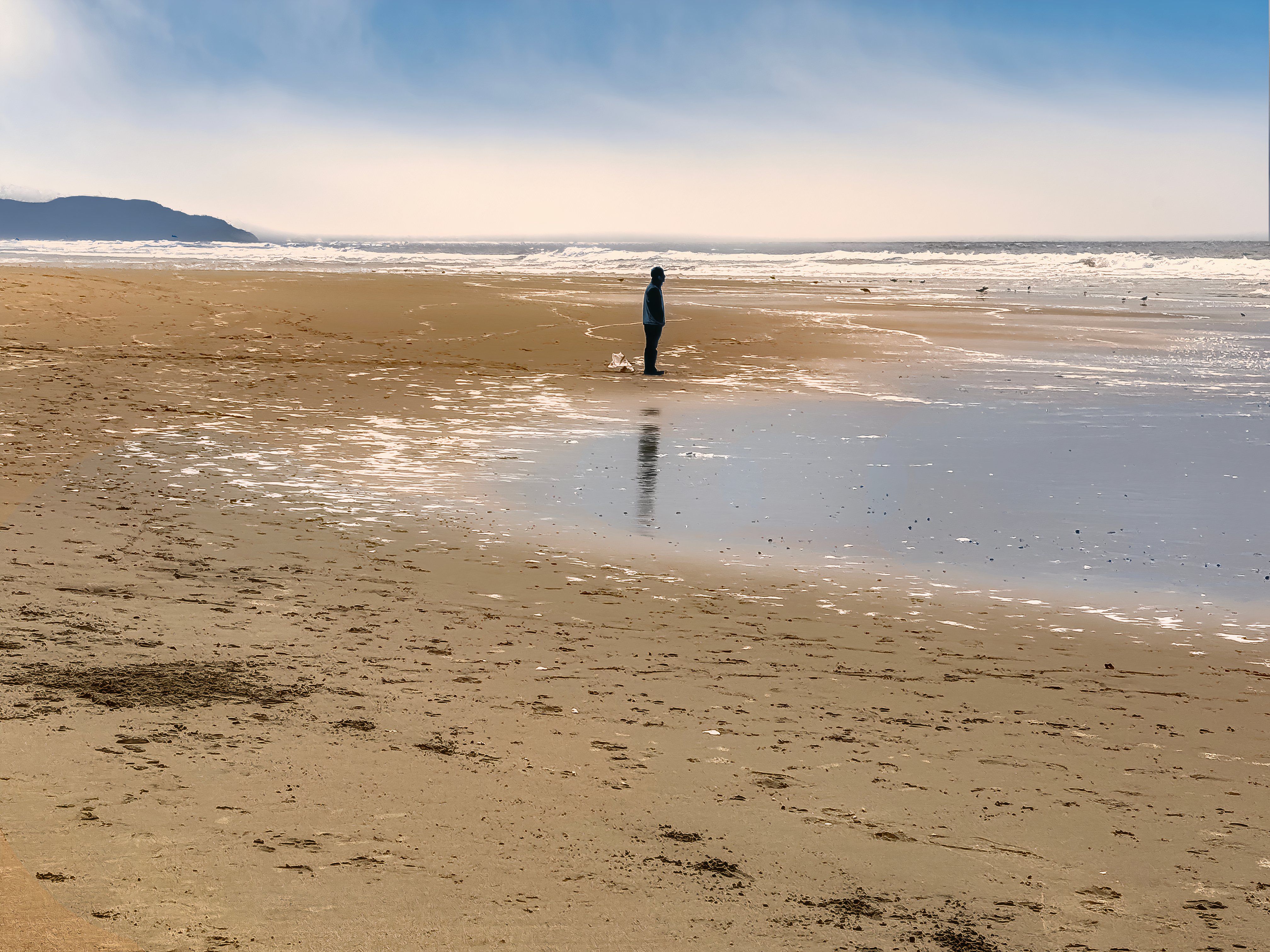 Man standing in silhouette at Sunset Dunes Park, along the Pacific ocean, San Francisco, California