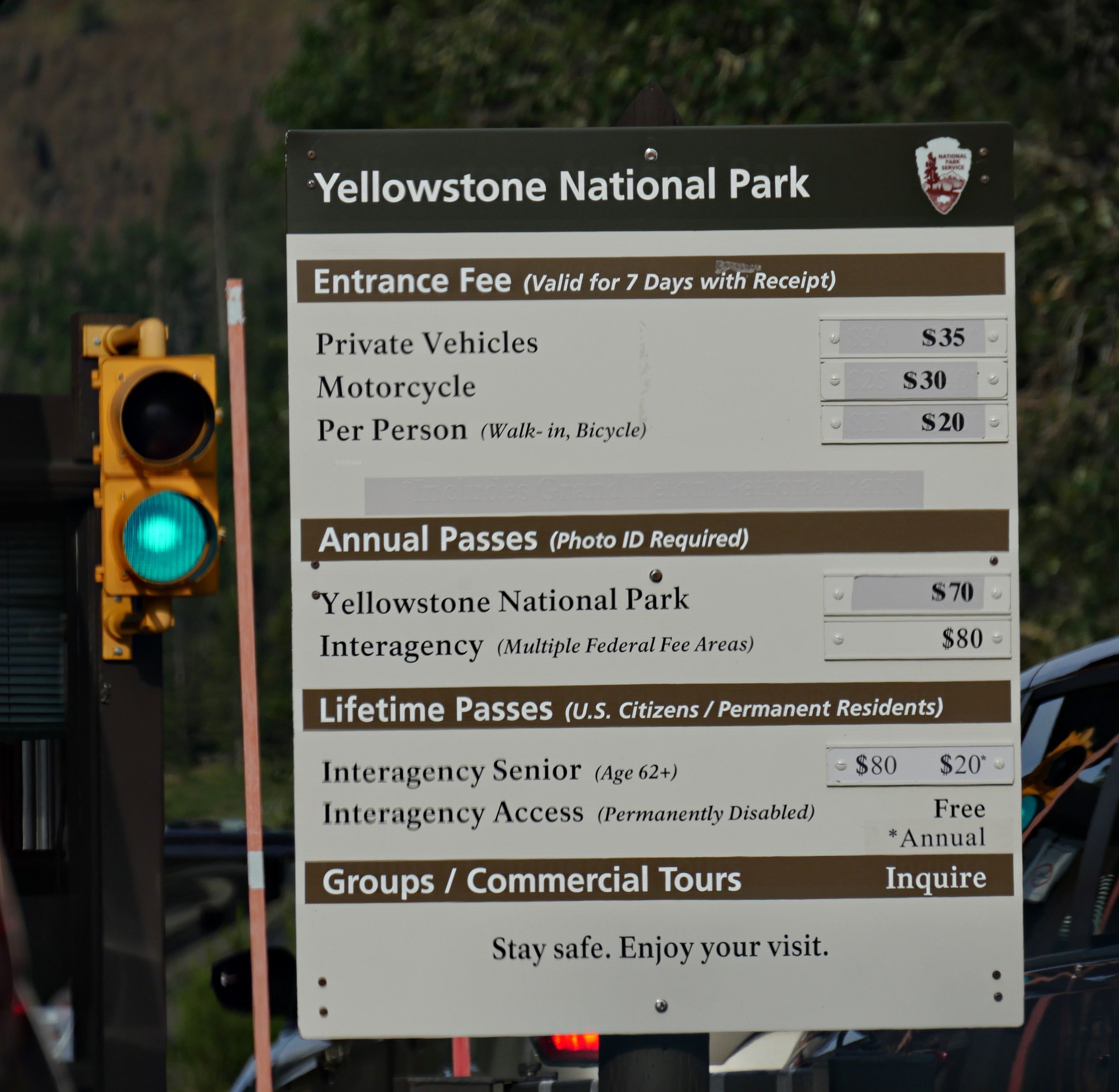View of an informational board with the admission fees at the east entrance of Yellowstone National Park, Wyoming, WY, USA.