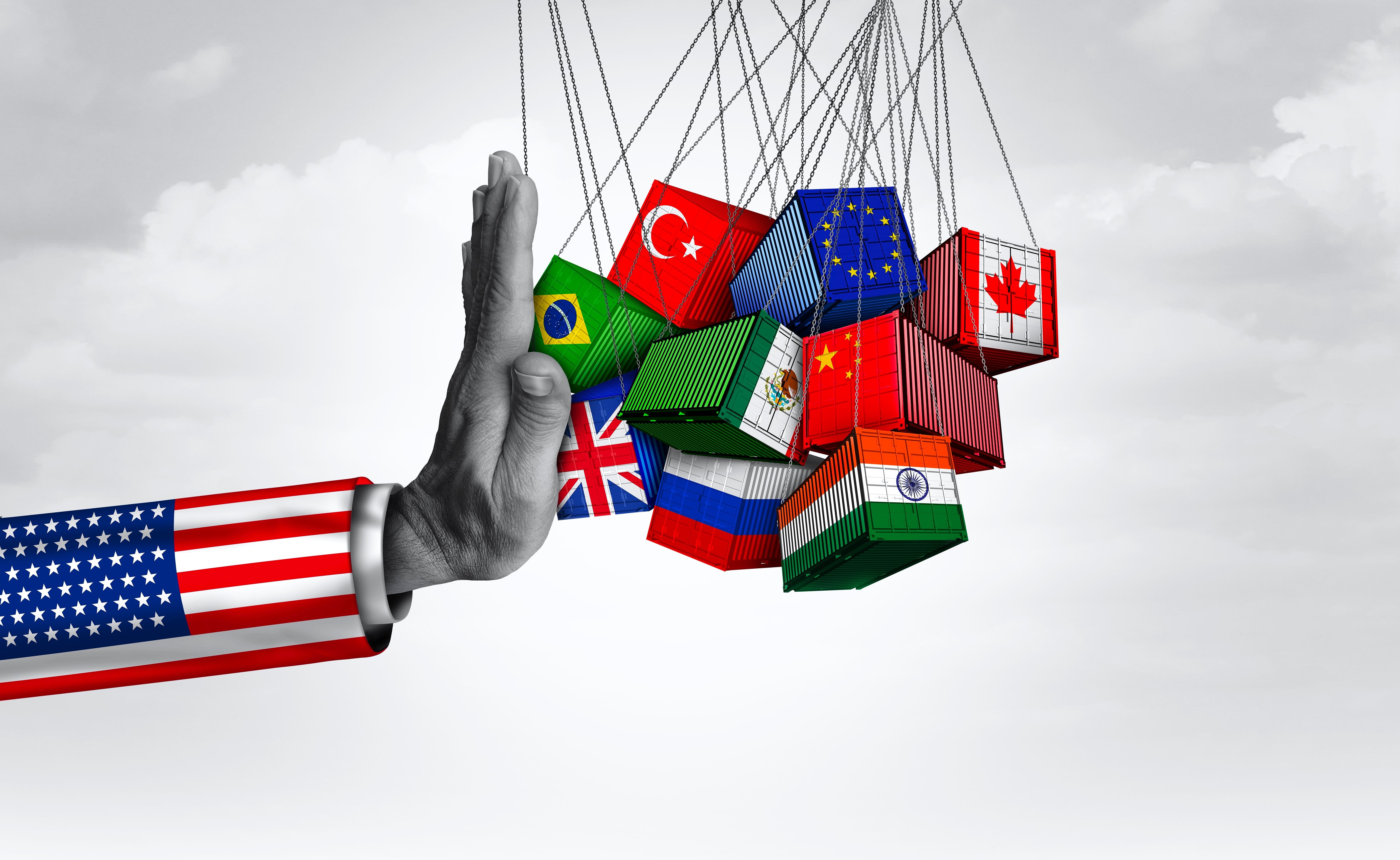 A hand with the USA flag on its cuff pushing away boxes with other countries' flags on them