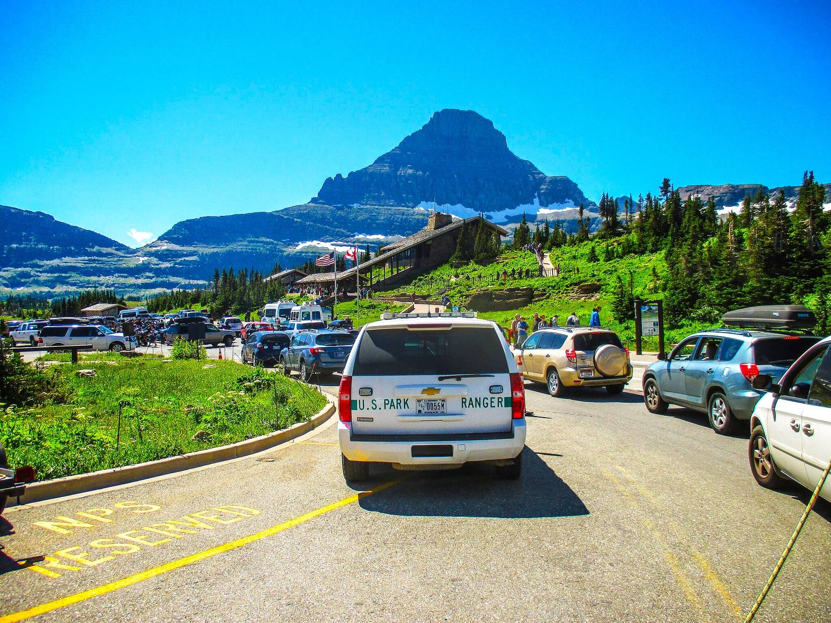 Crowded Logan Pass parking lot entrance with vehicle traffic congestion in Glacier National Park, Montana, MT, USA