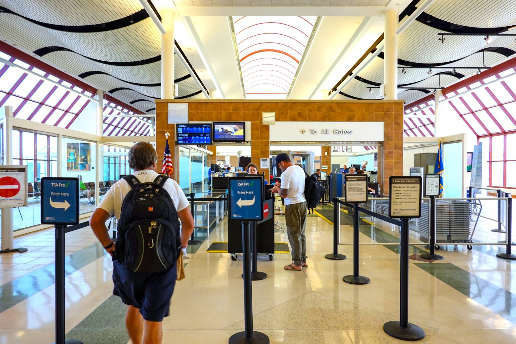 Travelers going through the TSA Precheck line and the regular line through airport security.