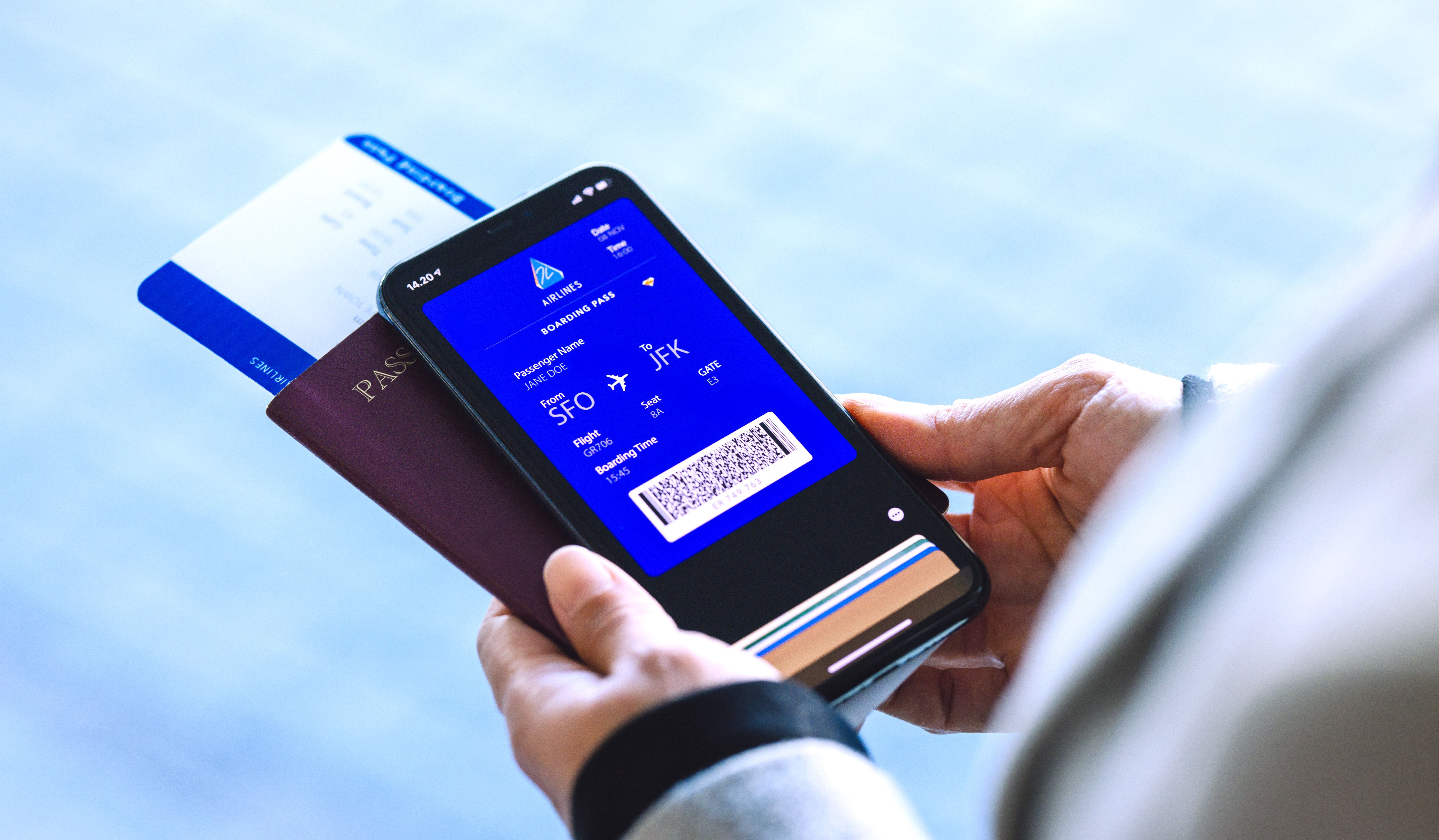 A traveler holding a mobile phone with an electronic boarding pass.